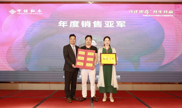 浙江省工艺美术大师、浙江中信红木董事长李忠信（左）为2018年度销售亚军颁奖