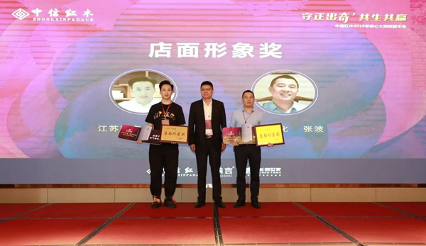 中信红木营销总监刘中炎（中）为中信红木2018年度店面形象奖获得者颁奖